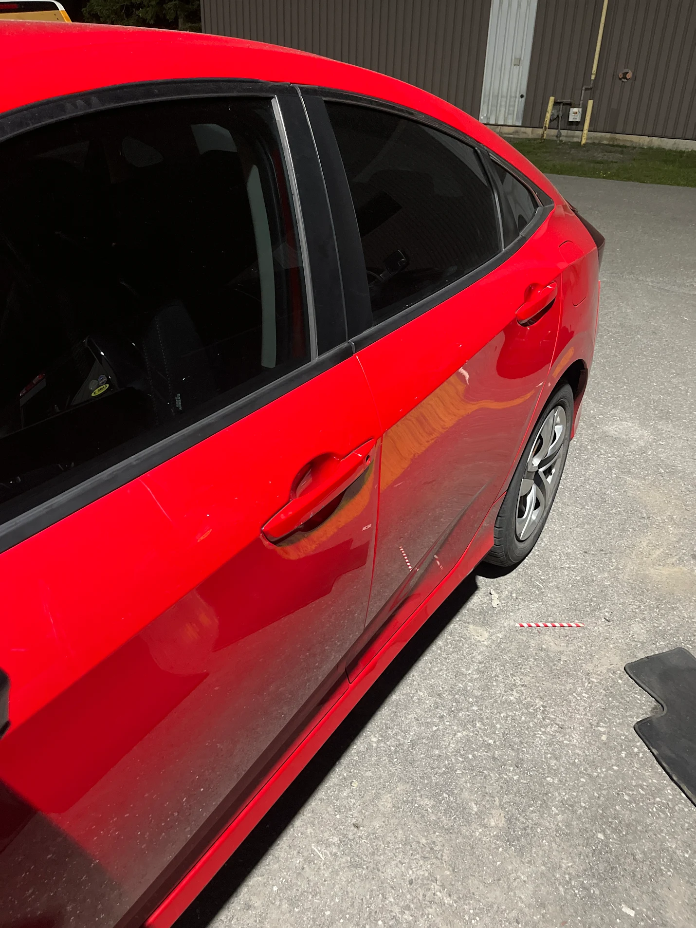 Red sedan with dark window tint installed by AutoWa Customs